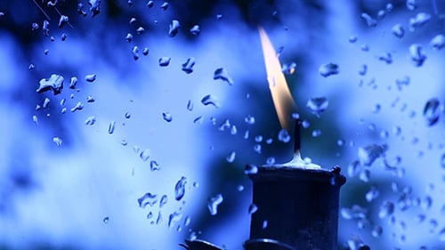 Candle Flame with Raindrops on a Window