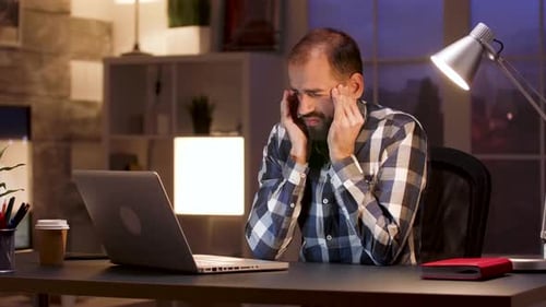 Überarbeiteter Geschäftsmann reibt Tempel im Home Office