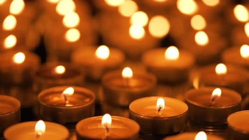 Many Small Burning Candles on a Black Background