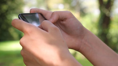 Hands Using Mobile Phone Outdoors, Close Up