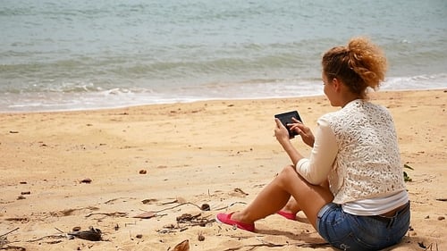 Woman on the Beach with Tablet Computer