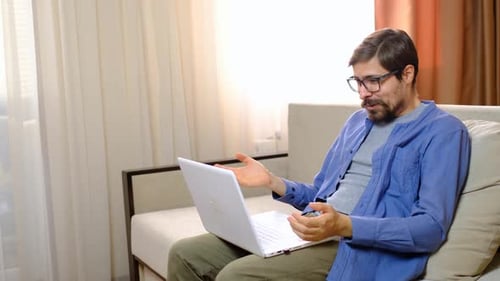 Man Talking on Laptop Video Call at Home