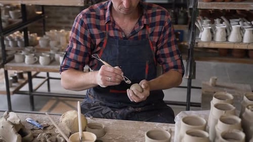 Potter Shaping Clay Sculpture in Pottery Workshop