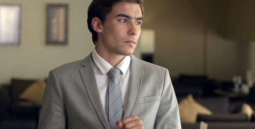 Man in Suit Uses Mobile Phone Indoors