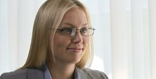 Woman in Business Attire Uses Tablet at Desk