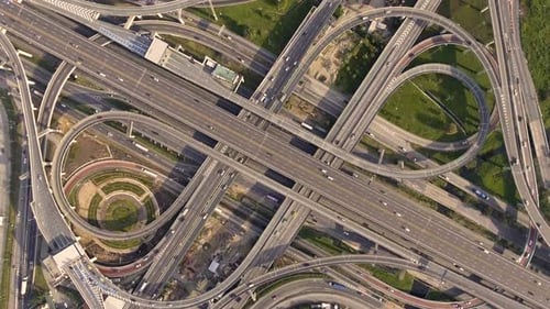 Aerial View of Highway Road Interchange with Busy Urban Traffic Speeding on Road