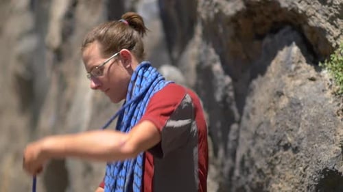 A young man preparing his rope before going rock climbing.