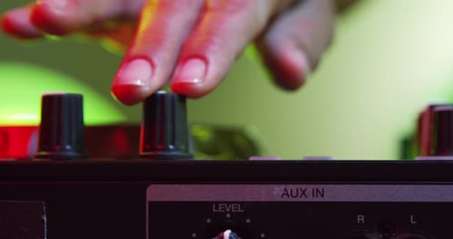 Finger Adjusting Controls on DJ Mixing Board