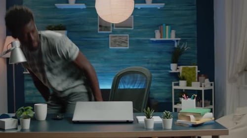 Young Adult Man Working on Laptop at Desk