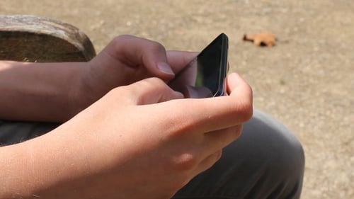 Close Up of Hands Using Cell Phone Outside