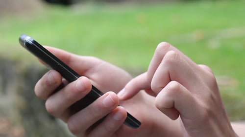 Hand Using Smartphone Outdoors Close Up