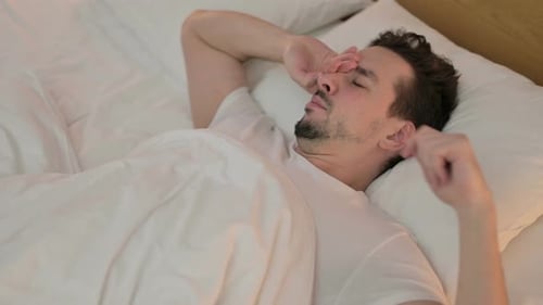 Man Waking Up, Stretching and Smiling in Bed