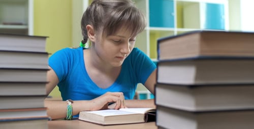 Concentrated Student Reading Books in Classroom