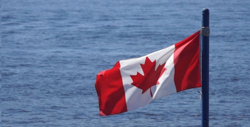 Canadian Flag Waves in the Wind by Water