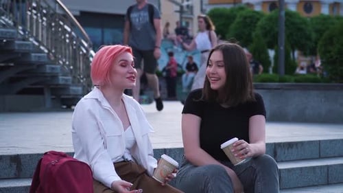 Two Young Women Chatting and Laughing in the City
