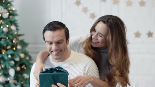 Loving Couple Exchanging Christmas Presents at Home