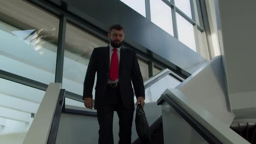 Cute Caucasian Man Chief Executive Officer Descends the Stairs in the Office of a Modern Company