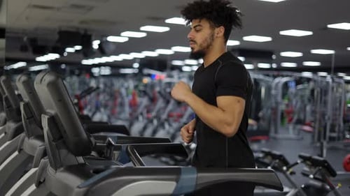 Runner Man Training on Treadmill Machine at Workout in Fitness Center