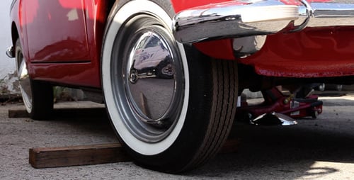 Restored Red Car Elevated on Hydraulic Jack
