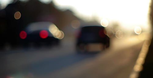 Out of Focus Cars on Road at Sunset