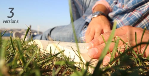Man Relaxing in Grass Reading and Writing
