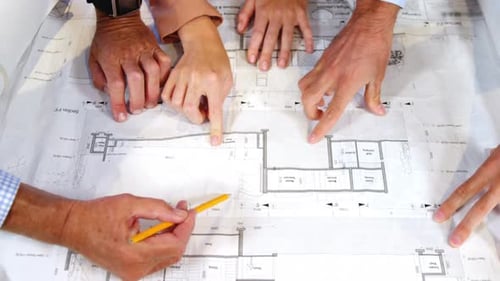 Architects Collaborate on Project Blueprints in Office
