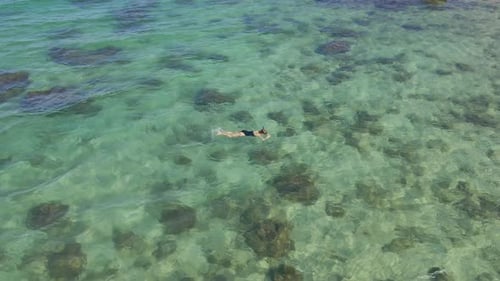 Aerial Shot of a Young Woman Snorkeling in a Clear Blue Sea Water