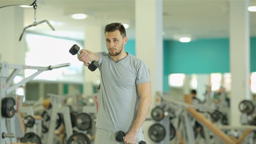 Junger Mann trainiert mit Hanteln