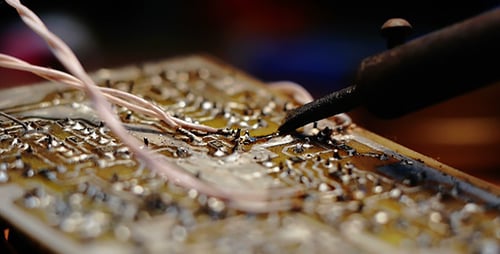 Soldering Wires on Aged Circuit Board Close Up