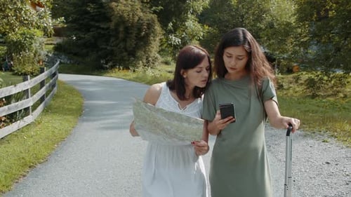 Chicas turistas que buscan una dirección de reserva