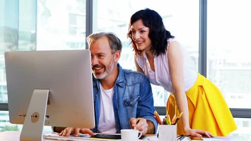Colleagues Collaborating on Computer in Bright Modern Office