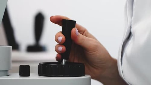 Healthcare Professional Manipulating Medical Device in Bright Light