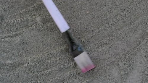 Brush Creates Abstract Patterns in Gray Sand