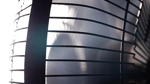 Oscillating Fan Grill in Motion Against Bright Light