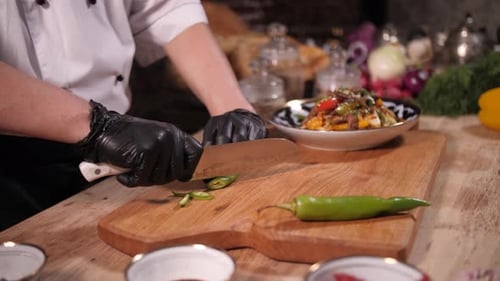 Chef Slices Green Chili Pepper on Cutting Board