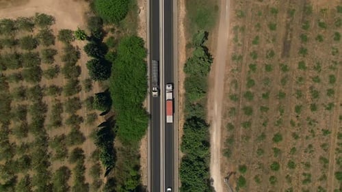 Truck loaded with Shipping Container driving on a rural highway, Aerial follow footage.