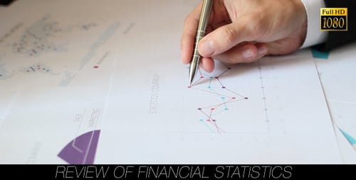 Hand Holding Pen Points At Line Graph On Paper