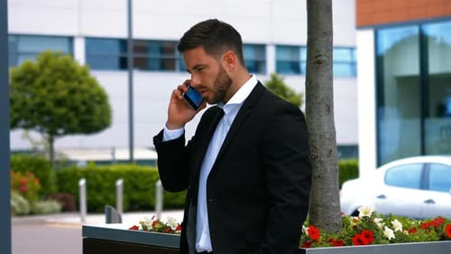 Well-Dressed Man Talking on Phone Outside Office