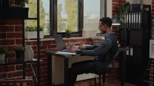 Young Adult Working at Desk in Modern Office