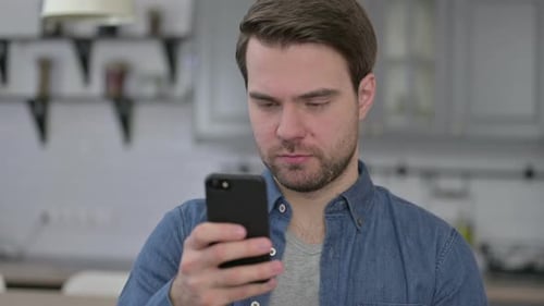 Porträt eines jungen Bartmannes mit Smartphone