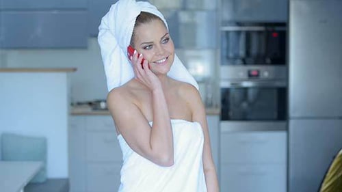 Woman in Towel Talking on Smartphone Indoors