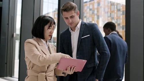 Business Colleagues Collaborate Using Tablet Device in Office