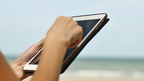 Woman Using a Tablet On Beach