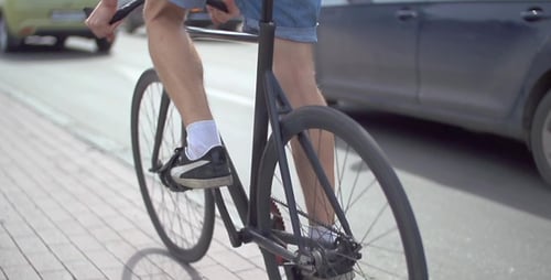 Person Riding Bicycle on City Street