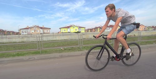Cyclist Rides Fixed Gear Bike on Urban Road