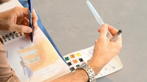 Sketcher Drawing in a Book