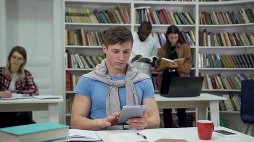 Smiling Student Using Tablet in University Library