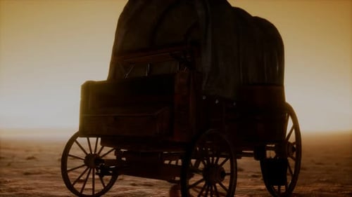 Vagón retro cubierto de lona en el desierto al atardecer