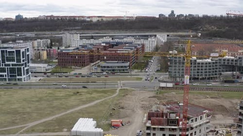 Grúas torre altas en el sitio de construcción con tráfico de automóviles, ciudad de Praga.