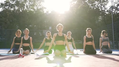 Women Practicing Yoga Outdoors in Golden Sunlight